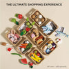 The Bakery & Patisserie Wooden Market Crate, filled with pretend play toy foods like eggs, fish, cheese, and fruits, is neatly arranged on a light surface. Text above reads: “The Ultimate Shopping Experience – Baker's Basket.”.