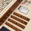 The 3-in-1 Game Collection features a Scrabble board with four tile racks (“ARGEN,” “FRIENDO,” “DATENI,” “LAX WORD”) plus Trivial Pursuit cards, dice, and pie tokens for extra fun at the table.
