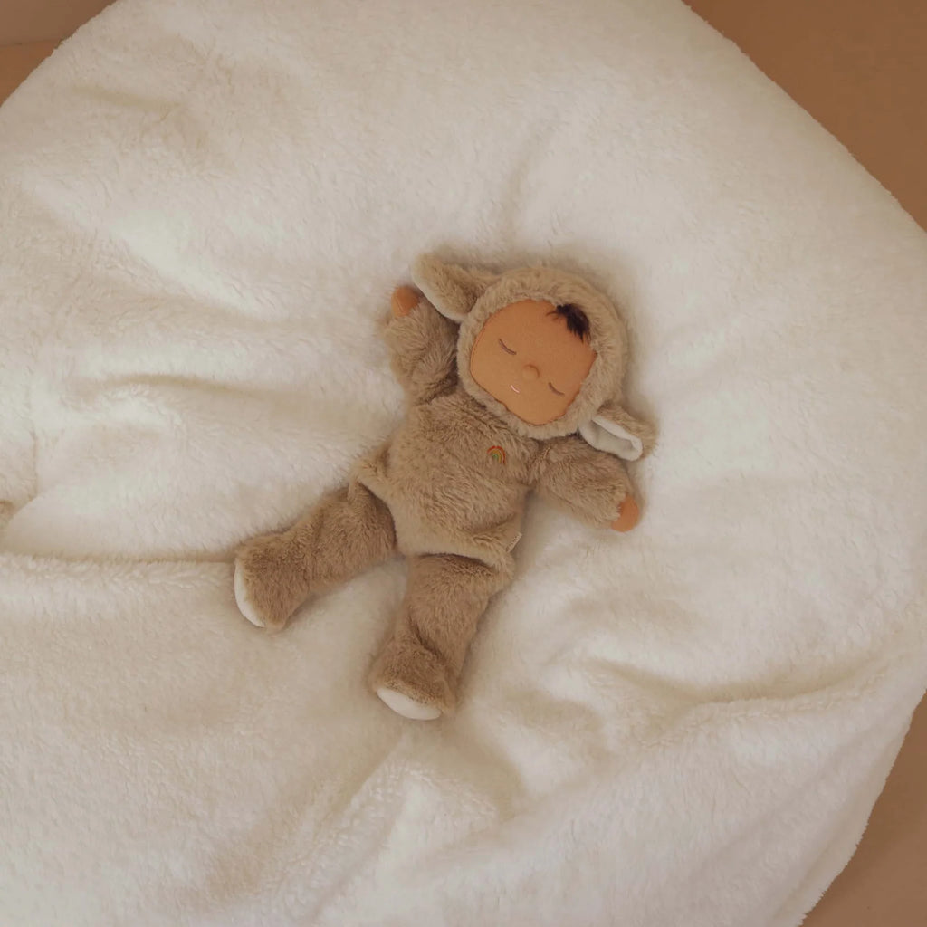 Meet your new favorite Olli Ella Cozy Dinkum Doll – Lamby Pip: a cuddly plush in a soft lamb suit with floppy ears, resting on a plush white blanket and perfect for snuggles.