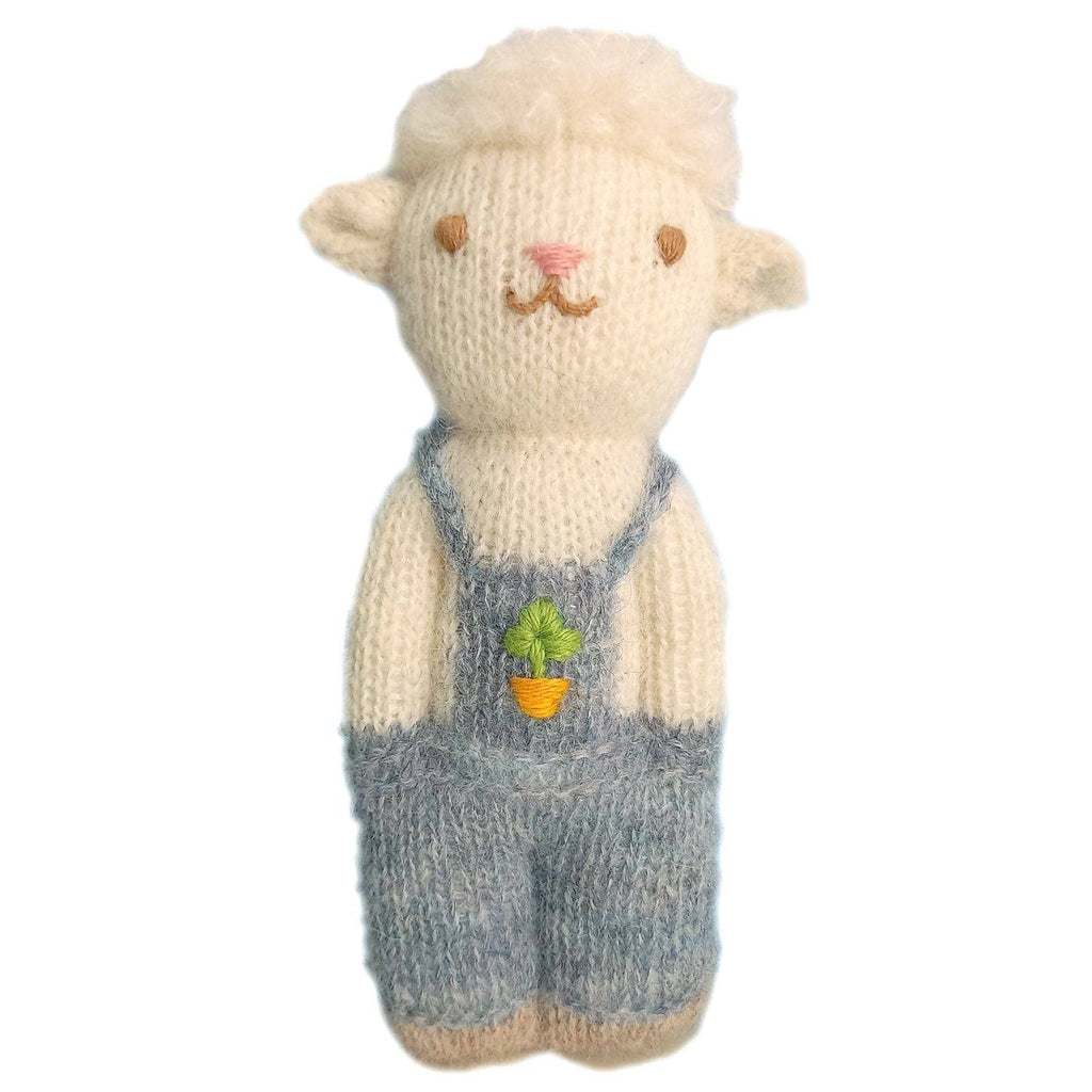 The Organic Alpaca Wool Doll - Sheep is a handmade, cream-colored stuffed animal by Blabla, crafted from organic alpaca fleece and dressed in blue overalls with an embroidered carrot and green leaves.