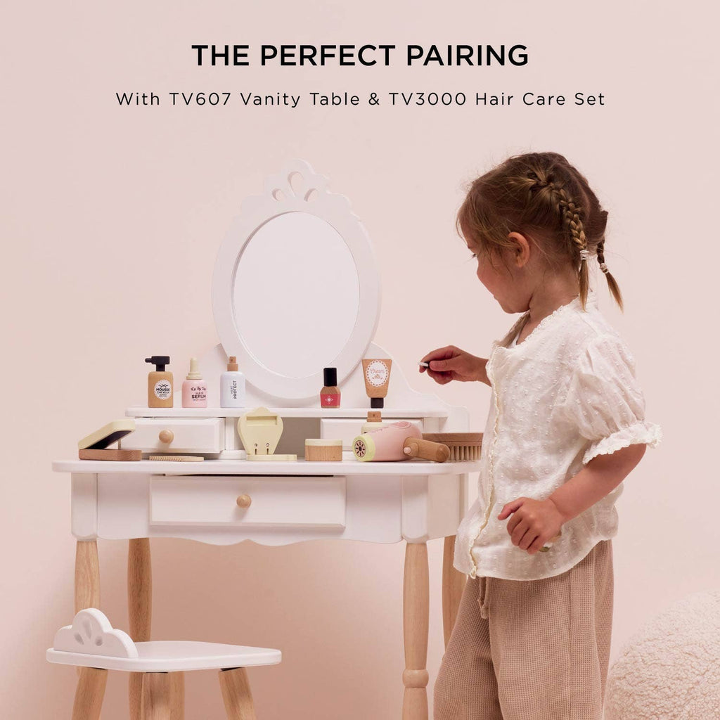 A young girl stands at a white vanity table with a mirror, enjoying imaginative role-play with the Vanity Star Beauty Kit—a perfect addition to any kids’ beauty set.