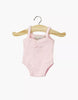 The Minikane 13" Doll Clothing | Anna Leotard in Jersey Cotton - Pale Pink is displayed on a small wooden hanger against a plain white background. This light pink leotard is designed for 13-inch dolls like Minikane.