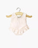 The Minikane 13" Doll Clothing | Maia Ruffled Leotard in Shiny Lycra - Pink is a light pink sleeveless onesie with a ruffled skirt, perfect for Minikane or 13 inch dolls, shown on a wooden hanger against a white background.