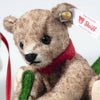 The Steiff Mama Teddy Bear With Child is a brown bear with a red scarf, gold ear button, and "Steiff Collectors" white tag. With black eyes and holding a green felt object, it's perfect for Christmas displays.