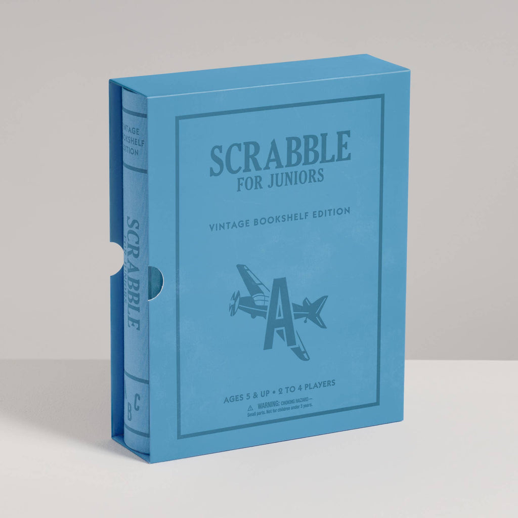 Blue, book-style game box for Scrabble for Juniors Vintage Bookshelf Edition, featuring an illustration of a letter A shaped like an airplane.