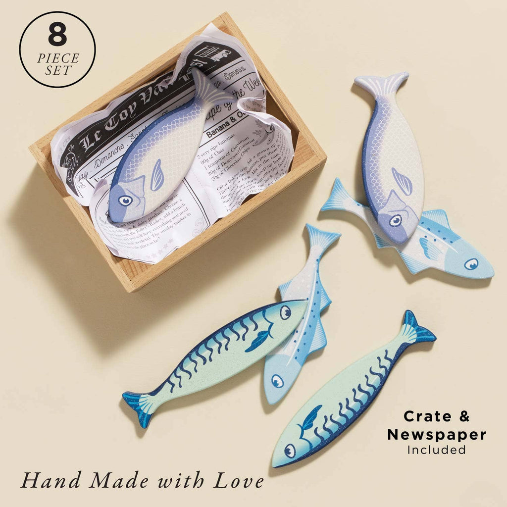 The Market Fish Wooden Play Market Crate includes six fish-shaped pieces and a paper-lined crate for pretend play. Features: "8 piece set," "Crate & Newspaper included," and "Hand Made with Love.
