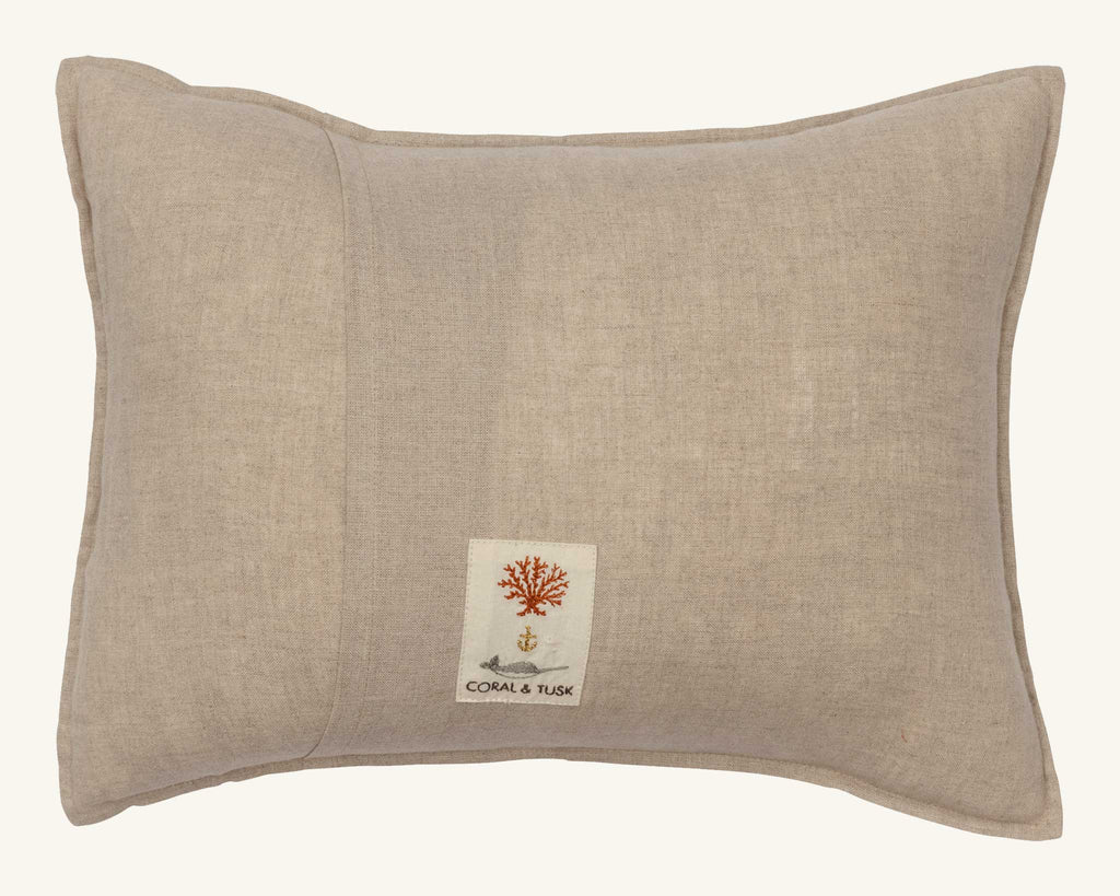 The Coral & Tusk Full Moon Masquerade Pillow is a beige, Oeko-Tex certified linen pillow with a stitched label featuring a red coral design, anchor, and “CORAL & TUSK” on the front.