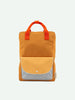 A rectangular orange Sticky Lemon Backpack Large | Farmhouse | Envelope | Homemade Honey crafted from waterproof nylon features two short orange handles. It has a front pocket with a flap; the main section of the pocket is light yellow and the flap is light gray with a white grid pattern secured by a snap button, embodying Sticky Lemon’s signature style.