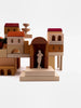 A complex structure made of various wooden blocks including arches and columns from the Sabo Concept Italian Courtyard Blocks, features a silhouette of a slender figure set within a central arch, against a white background.