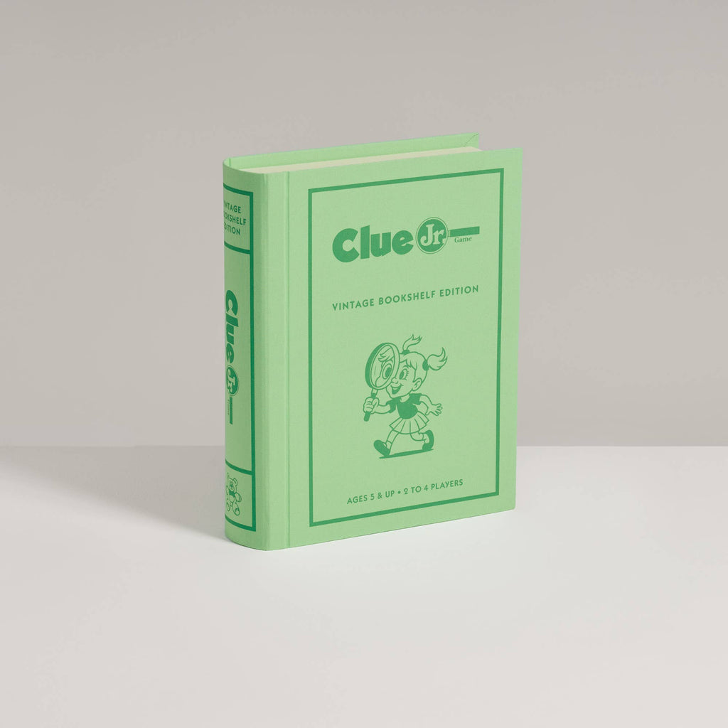 Light green Clue Jr. Vintage Bookshelf Edition board game box designed to look like a vintage book, featuring a cartoon character with a magnifying glass.
