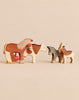 A set of Handmade Holzwald Farm Animals including a wooden horse, cow, donkey, goat, and chicken.