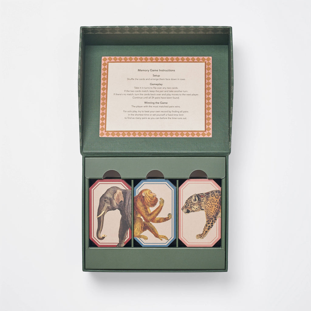 An open green box contains the Memory Game - Animal Kingdom with vintage animal illustrations (elephant, lion, leopard) on top. A card with game instructions is printed inside the lid.