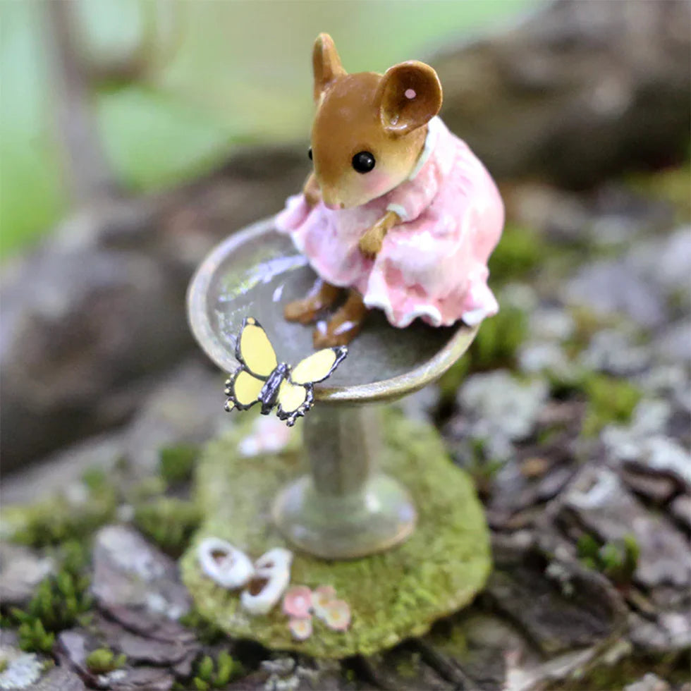 The Wee Forest Folk Tiny Collectible - Garden Spa features a hand-sculpted mouse in a pink dress on a mossy birdbath base, gazing at a yellow butterfly—a charming woodland miniature.