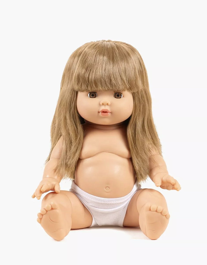 The Minikane Baby Doll (13") - Nina features long, straight blonde hair with bangs and sits upright in white underwear (clothing sold separately) against a plain white background.