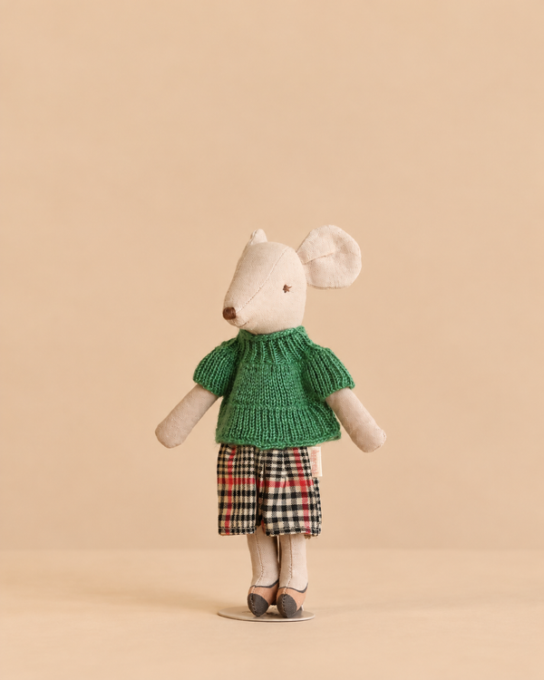 Maileg Grandma Mouse wearing a green knitted sweater and a plaid skirt, with magnets in her hands.