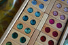 Bauspiel Large Gem Blocks, 45-Piece Set: wooden rectangular blocks, each set with two circular colorful gems, arranged in a wooden toy tray.