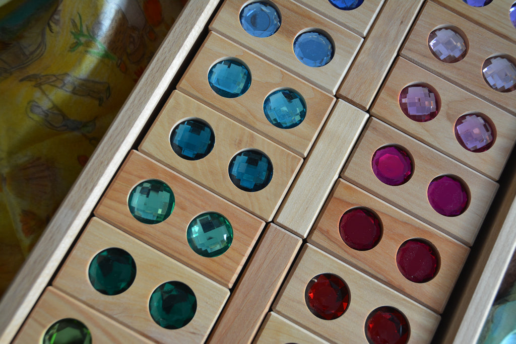 Bauspiel Large Gem Blocks, 45-Piece Set: wooden rectangular blocks, each set with two circular colorful gems, arranged in a wooden toy tray.