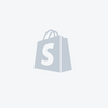 A gray icon of a book with a prominent "S" on the cover, set against a light gray background, evoking the delightful adventures of the Maileg Big Sister Tricycle Set.