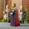 The Bumbu Handmade Wooden King features a king in a red and blue robe with a yellow crown, standing before two armored guards with spears and shields, set against a castle backdrop—a charming medieval playset addition.