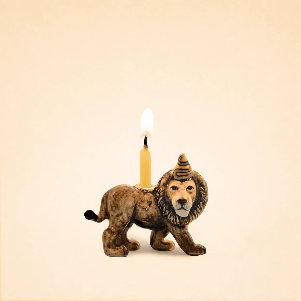 The Lion Cake Topper - Final Sale (ships in one week) is a handcrafted figurine featuring a party hat and candle, perfect as a charming birthday keepsake set against a beige background.