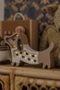 The Handmade Wooden Mini Lamp - Puppy, crafted from pine with glowing bulbs and heart cutouts, sits on a wicker shelf among plush toys—an ideal nursery decor piece for creating a cozy, softly lit room.