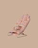 The PRE-ORDER: Babysitter, My - Rose is a small pink floral-patterned baby bouncer with sweet bunny designs, metal frame, and fabric safety strap. Estimated ship date: Late September. Set against a plain beige background.