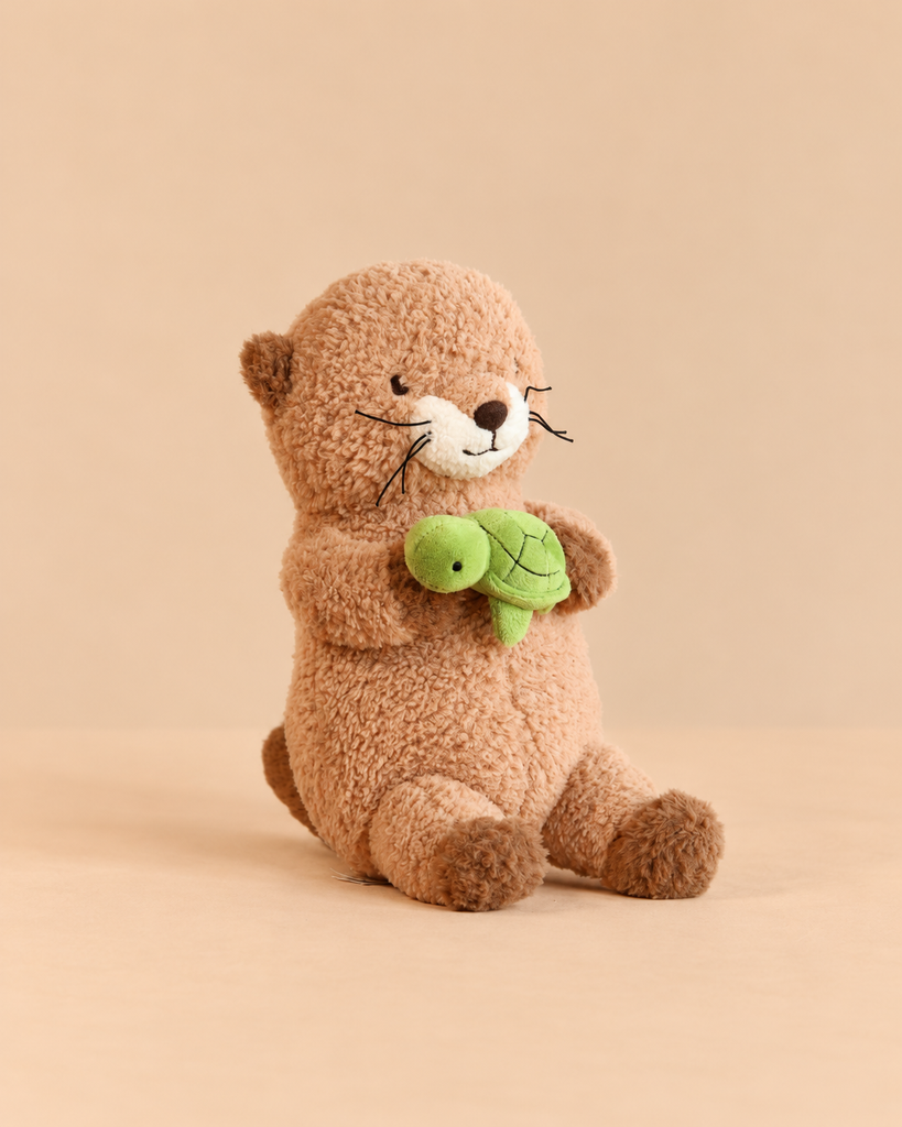 Snuggle Bunnies - Ollie the Otter - Cocoa is a brown plush otter sitting and holding a small green plush turtle.