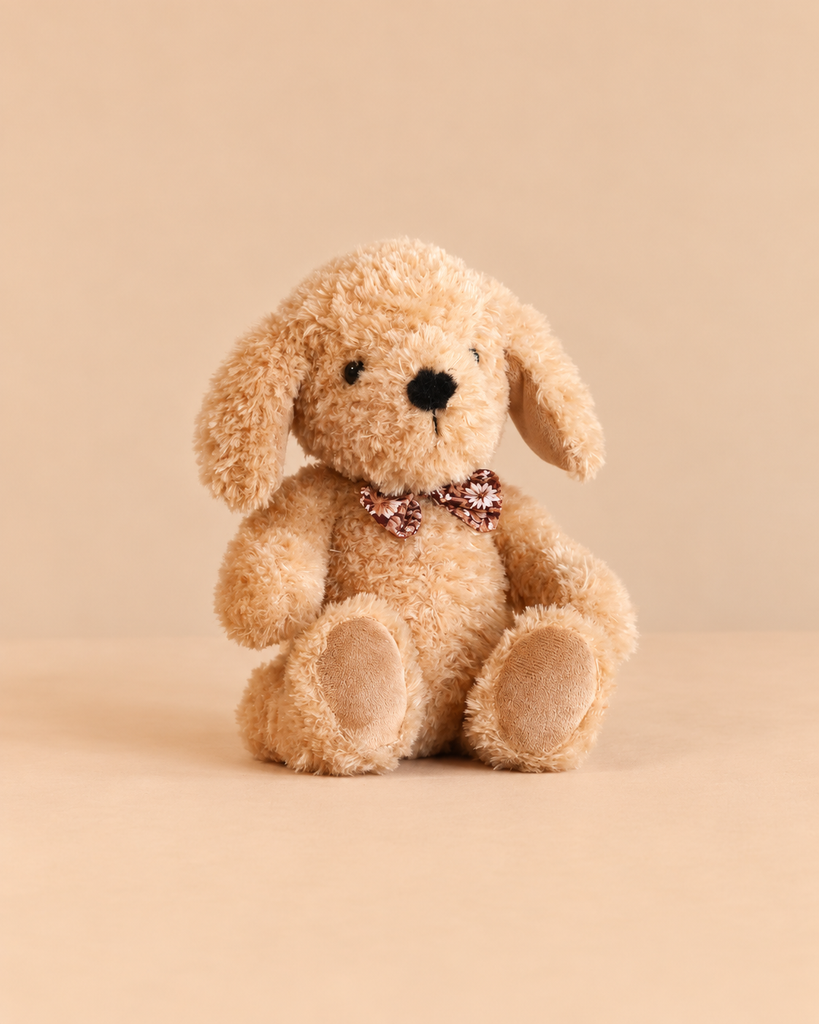 Snuggle Bunnies - Honey the Puppy is a tan plush stuffed animal wearing a small floral bow tie, a perfect cuddle companion.