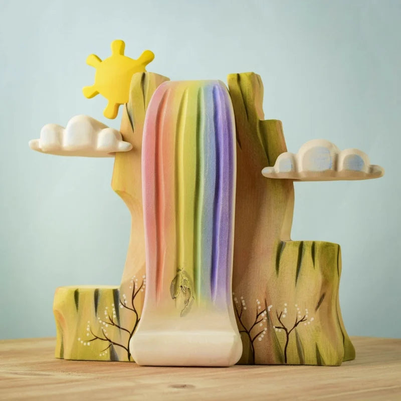 The Bumbu Wooden Rainbow Cliff (ships in one week) features a waterfall with rainbow streams, carved clouds, and a yellow sun on sustainably sourced wood—perfect for imaginative play.