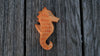 Handmade Holzwald Sea Horse ornament with painted stripes and details, representing a beautiful addition to any collection of sustainable toys.