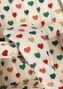 Close-up of a padded fabric strap with red, green, blue, and gold hearts on cream from the Konges Sloejd Doll Stroller - Colored Hearts, featuring removable quilted fabric.