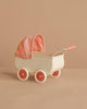 The Maileg Pram, Mouse - Coral features a vintage cream design with pink wheels and a pink checkered canopy, ideal for baby mice. Shown against a beige background.