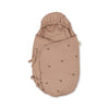 The Konges Sloejd Doll Sleeping Bag - Cherry Blush is a light brown, hooded sleeping bag with cherry prints, two side ties, and a soft organic cotton feel, shown against a white background.