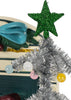 A miniature silver tinsel Christmas tree with a green glittery star and pastel ornaments placed in front of a Konges Sloejd Christmas Door.