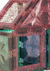 A house-shaped structure built from translucent, glitter-filled magnetic tiles in pink, green, and blue, created using the Konges Sloejd Piece By Piece Magentic Building Set.