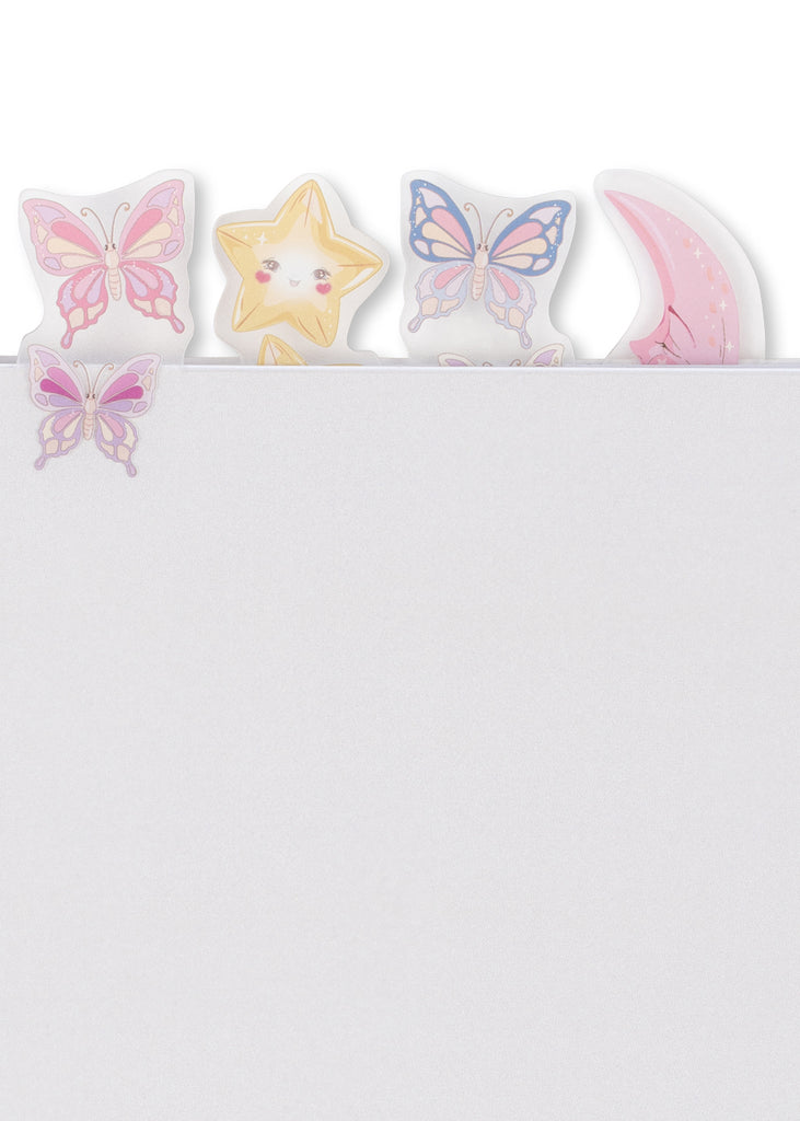 Five colorful stickers shaped like butterflies, a star, and a crescent moon from the Konges Sloejd My Stationery Box - Unicorn peek over the top edge of a blank white A5 notebook.