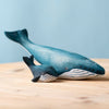 The Bumbu Handmade Wooden Blue Whale Family Set features two painted wooden whale figurines, large and small, on a light wood surface against a pale blue background—sustainable toys ideal for Montessori and imaginative play.