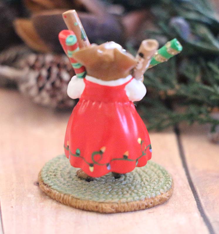The Wee Forest Folk Tiny Collectible - Wrap it Up! (Not a Toy) features a hand sculpted mouse in a red dress with garland, standing on a mat and holding three gifts among pinecones and greenery—a charming miniature scene.