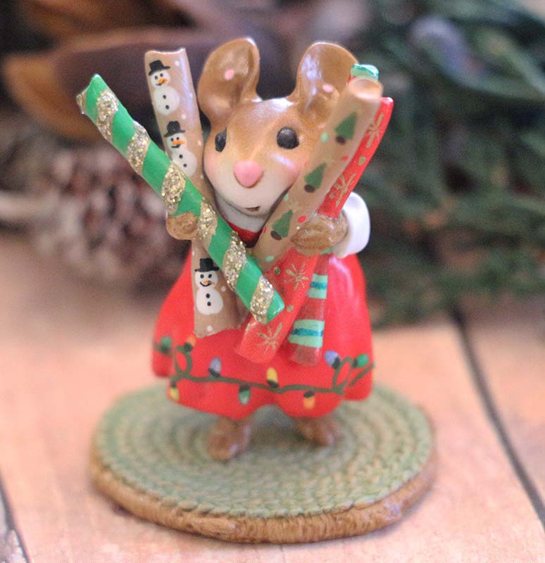 The Wee Forest Folk Tiny Collectible - Wrap it Up! features a hand-sculpted mouse in a red holiday dress holding three rolls of wrapping paper, standing on a round woven mat.