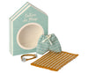A small cardboard box with "Cabine de Plage" written on it houses the perfect beach accessories: a pair of striped blue shorts, a matching bracelet, and a yellow-and-white striped beach mat. The box design resembles a charming beach cabana, making it an ideal fit for the Maileg Beach Set for Big Brother.