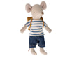 A Maileg Big Brother With Backpack dressed in a striped blue and white t-shirt, denim shorts, and a small brown school backpack, standing against a white background.