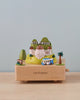 The Los Angeles Wooden Music Box showcases miniature models of iconic Los Angeles landmarks, such as the Hollywood sign, Griffith Observatory, and a blue-and-yellow bus. The base, inscribed with "Los Angeles," rests on a wooden surface, making it an ideal keepsake gift that celebrates the city's unique cultural landmarks.