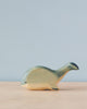 Handmade Holzwald Whale toy on a neutral background, featuring simplistic design and smooth finish with a blend of natural wood tones and green paint. This sustainable toy exemplifies high-quality craftsmanship that appeals to both aesthetic and