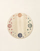A wooden plate with artistic floral and geometric designs painted in various colors around the rim, set against a plain white background, resembling elements of the Grapat Seasonal Platform.