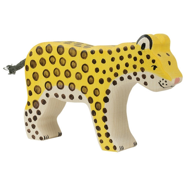 The Holztiger Leopard, handcrafted in Europe, showcases a yellow body with brown spots and black-tipped ears. Its simplistic design includes a green string tail, and like all HOLZTIGER figures, it stands proudly on four legs against a white background.