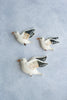 Three Flying Seagulls Wall Decor with white bodies and detailed wing patterns arranged on a light blue textured background.