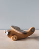 Wooden airplane with light blue propeller on natural color counter and light blue background. 