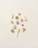 Assorted small, pastel-colored Grapat Wonders Play Set from sustainable forests, including spinning tops, blocks, and shapes, arranged neatly on a light background.