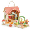 The Rosewood Cottage playset features a woodland cottage with a removable roof, miniature sleeping figure, stove, and kitchenette. It includes mushroom figurines, flowers, and a swing set for an enchanting meadow vibe.
