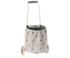 The Maileg Trolley, Multi dots - Blue is a small pushcart with a washable linen basket in colorful polka dots, two wooden wheels, and a gray handle.